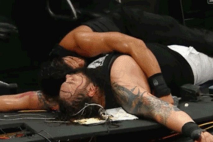 Roman reigns and  Bray Wyatt lay on the ruins of a table during a WWE hell-in-a-cell match in 2015.