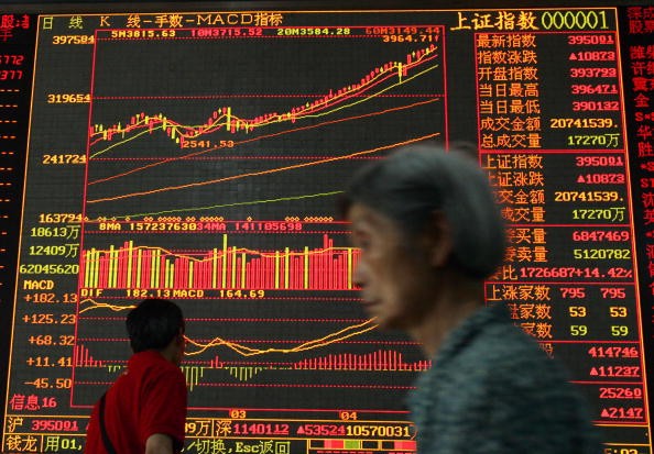 An investor walks past an electronic screen displaying stock index at a securities company in Wuhan, Hubei Province, China, on May 8, 2007. 