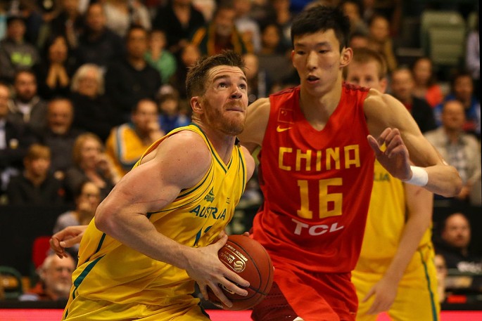 Chinese center Zhou Qi defends against Australia's Lucas Walker.