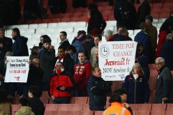 Arsenal fans hold banners after the Barclays Premier League match between Arsenal and West Bromwich Albion.