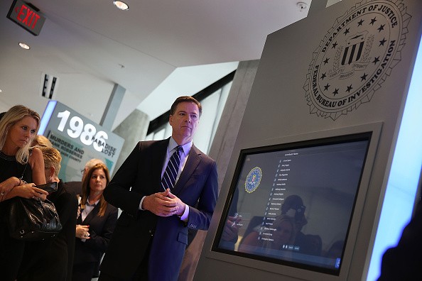 FBI Director James Comey looks on at a memorial built in the lobby of the Miami Field Office including a list of agents killed on duty in a gun battle with two heavily armed suspected bank robbers in 
