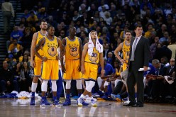 Golden State Warriors players and assistant coach Luke Walton stands on the court.