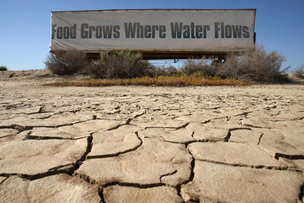 A sign on a farm trailer reading 'Food grows where water flows,' hangs over dry, cracked mud at the edge of a farm April 16, 2009 near Buttonwillow, California. 