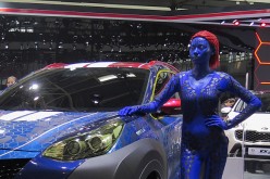 A model stands by a KIA vehicle at the Beijing International Automotive Exhibition on April 25, 2016 in Beijing, China. 