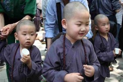 Kids wearing Buddhist clothing take part in an event of 