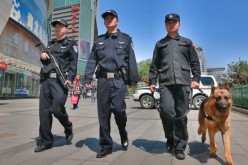Police officers and a dog patrol a street on May 12, 2014 in Beijing, China.