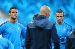 Real Madrid forwards Cristiano Ronaldo (L) and Gareth Bale listen intently to head coach Zinedine Zidane during training.