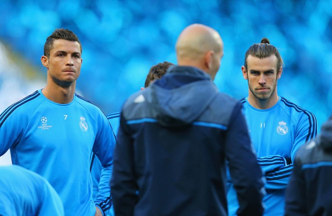 Real Madrid forwards Cristiano Ronaldo (L) and Gareth Bale listen intently to head coach Zinedine Zidane during training.