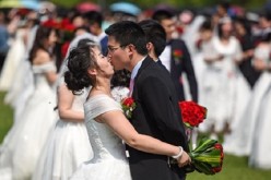 Sealed with a kiss: A newlywed couple share a kiss during a huge wedding held at Zhejiang University on April 30.