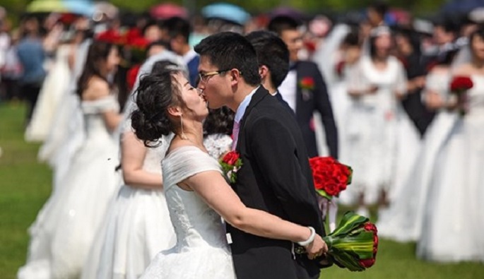 Sealed with a kiss: A newlywed couple share a kiss during a huge wedding held at Zhejiang University on April 30.