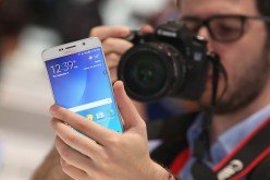 A visitor looks at a Galaxy Note 5, not the Galaxy Note 6, smartphone at the Samsung stand.