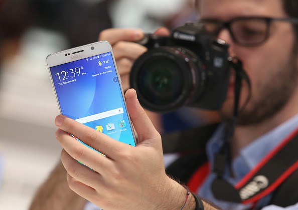 A visitor looks at a Galaxy Note 5, not the Galaxy Note 6, smartphone at the Samsung stand.